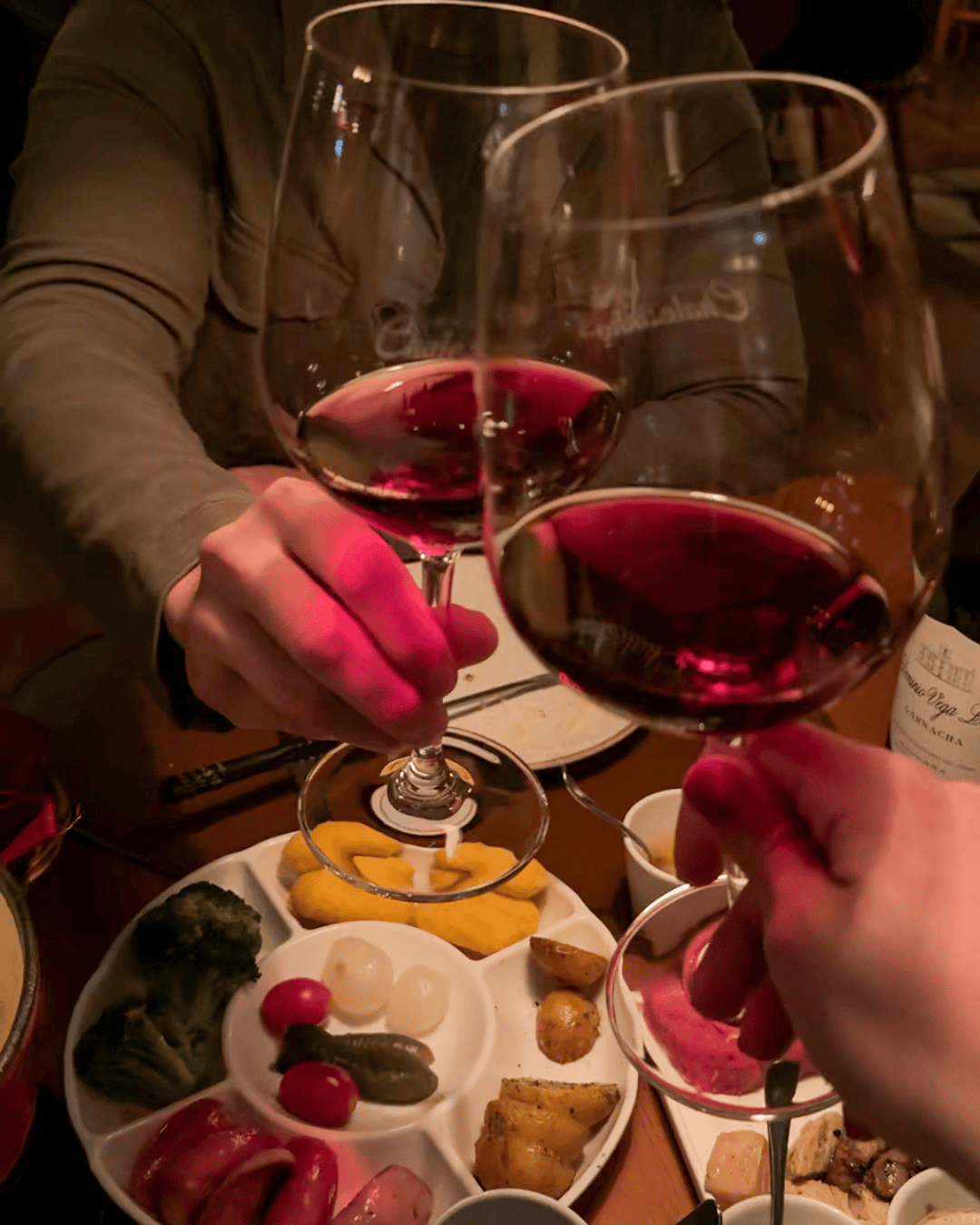 Lorrane e João brindando com vinho tinto no Chalezinho